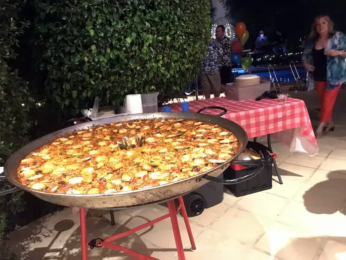 Large paella pan cooking at an evening celebration